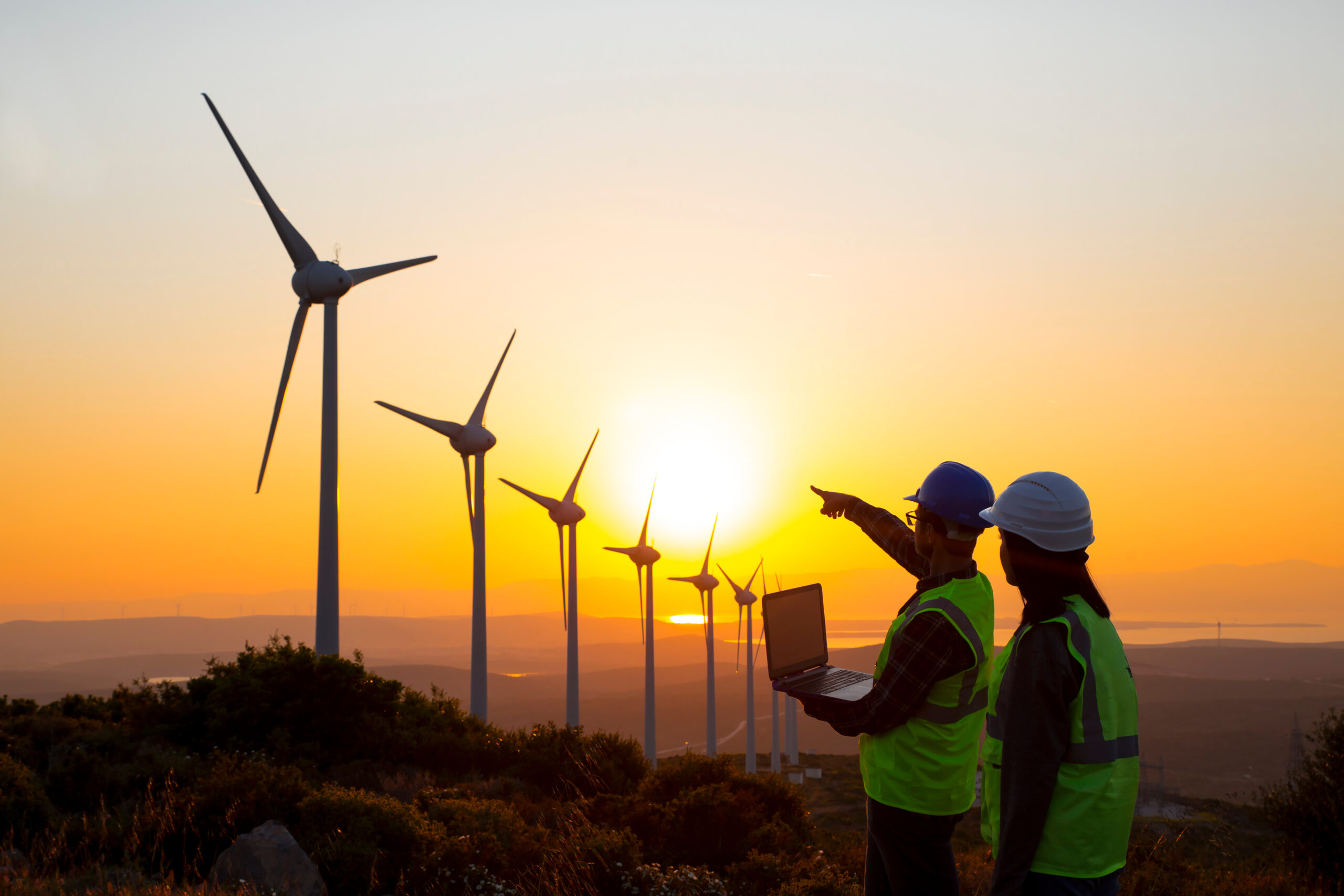 Young,Maintenance,Engineer,Team,Working,In,Wind,Turbine,Farm,At